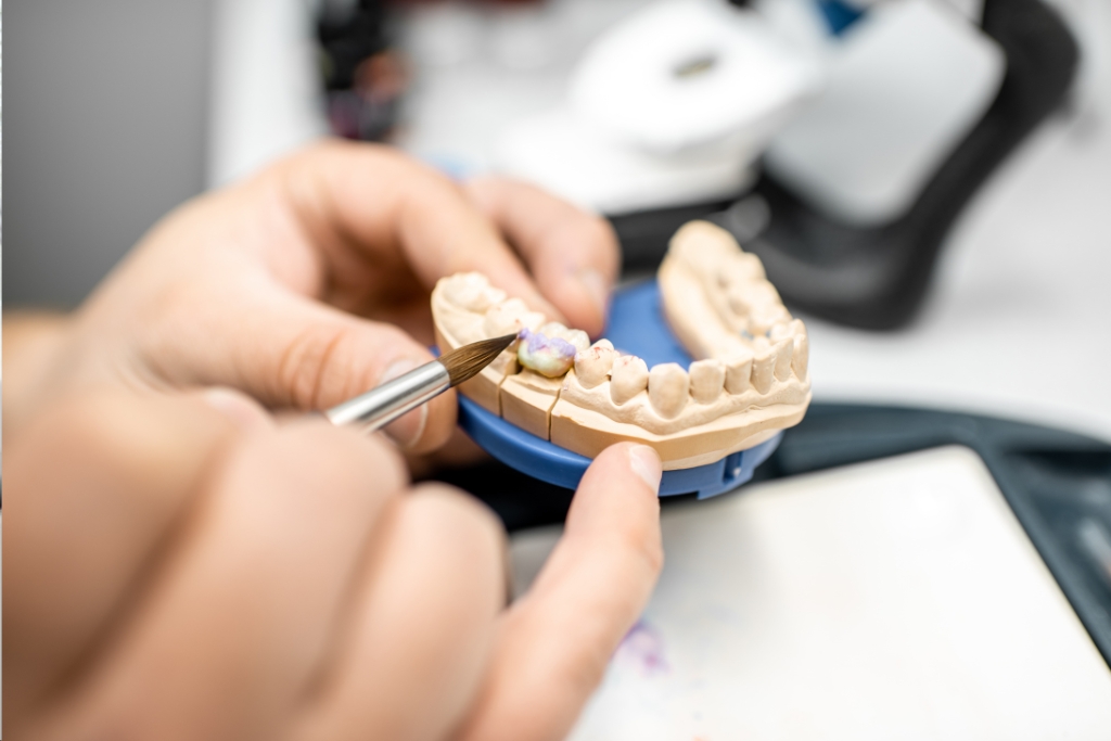 Prótese dentária ou implante